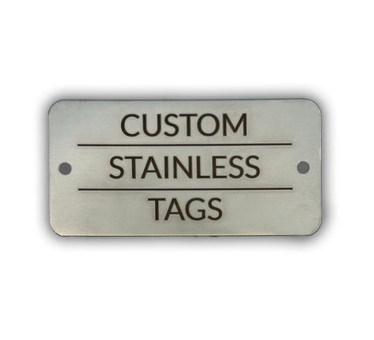 A rectangular stainless steel tag with the text 'CUSTOM STAINLESS TAGS' engraved on it.