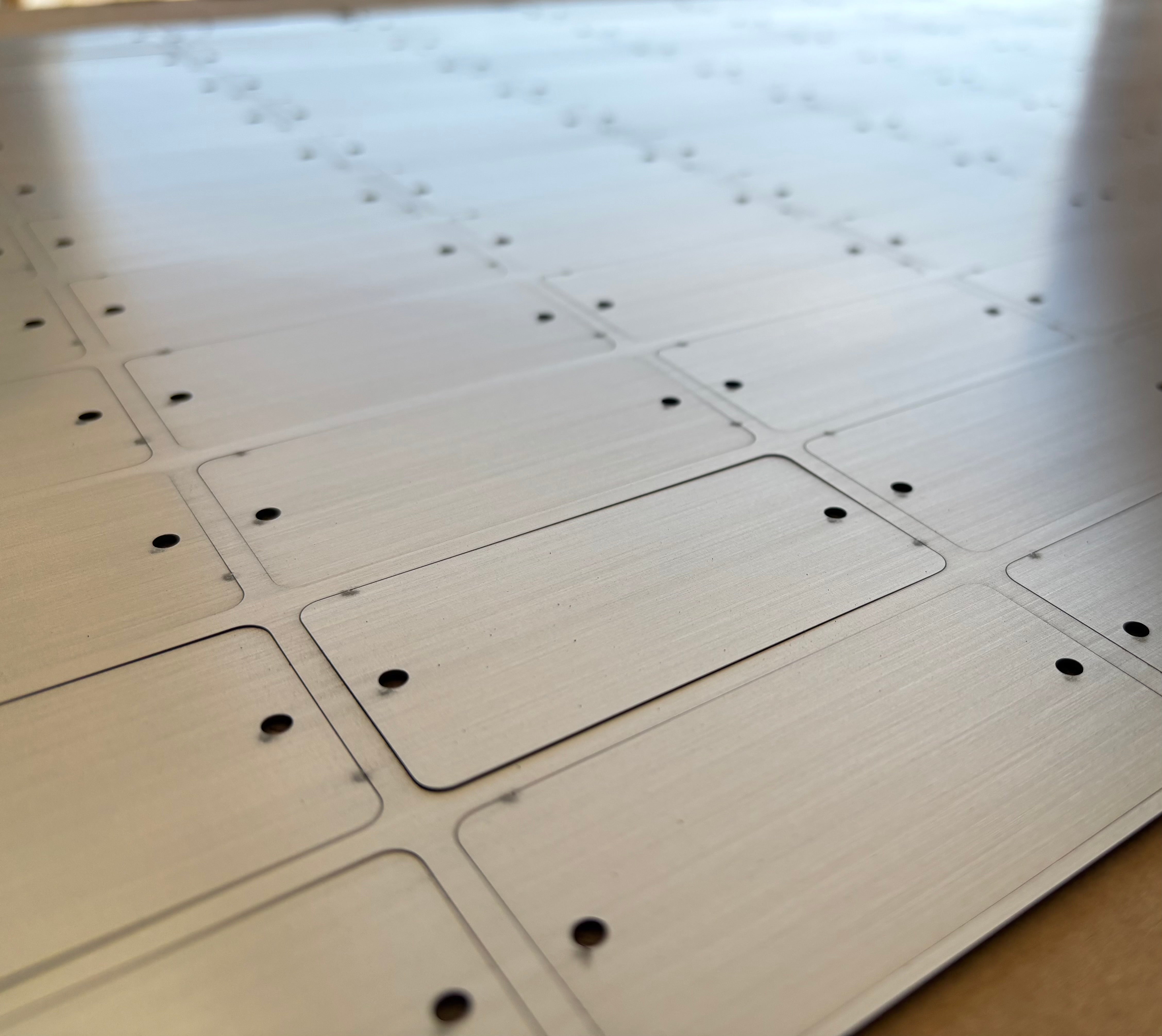 Stainless metal tags cut in the Custom Cutouts production shop