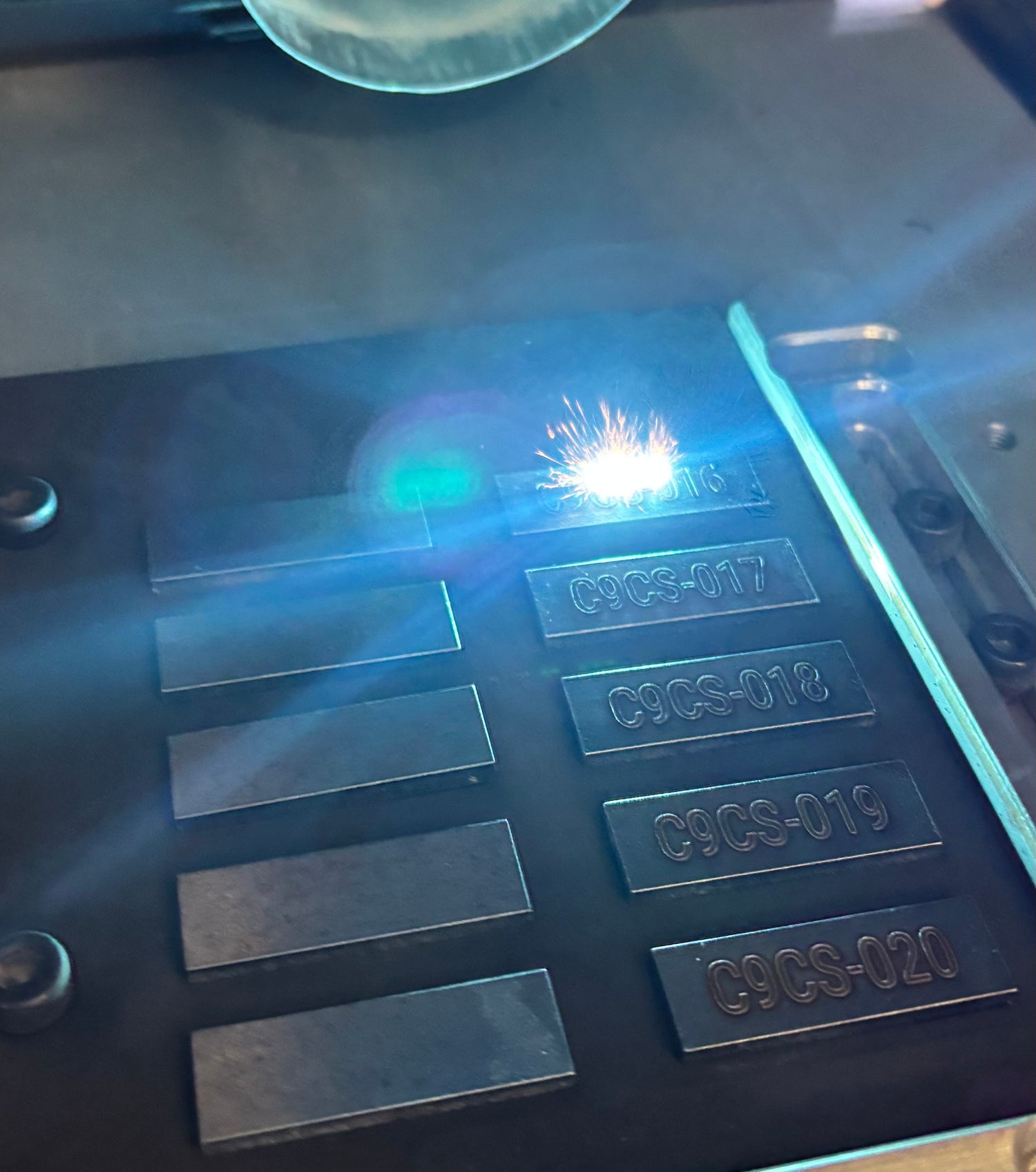 Metal stamping process with numbers being engraved on metal plates.