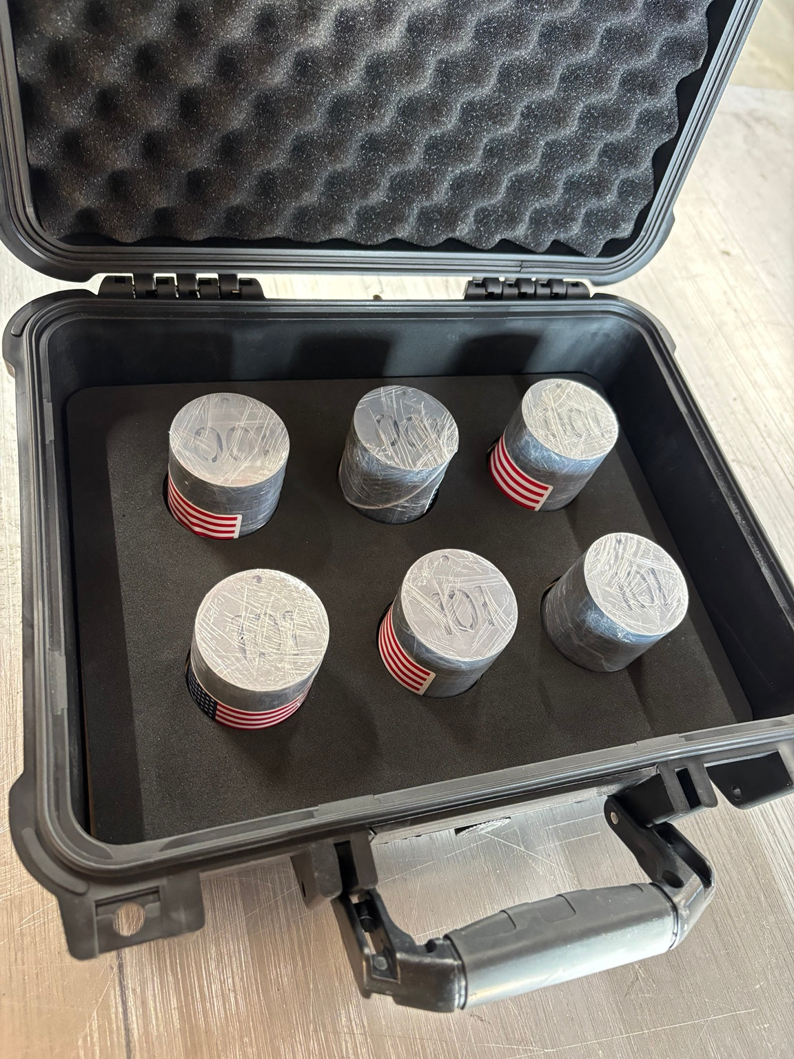 Six bundles of 100 cut-through stainless tags packaged in a waterproof project case