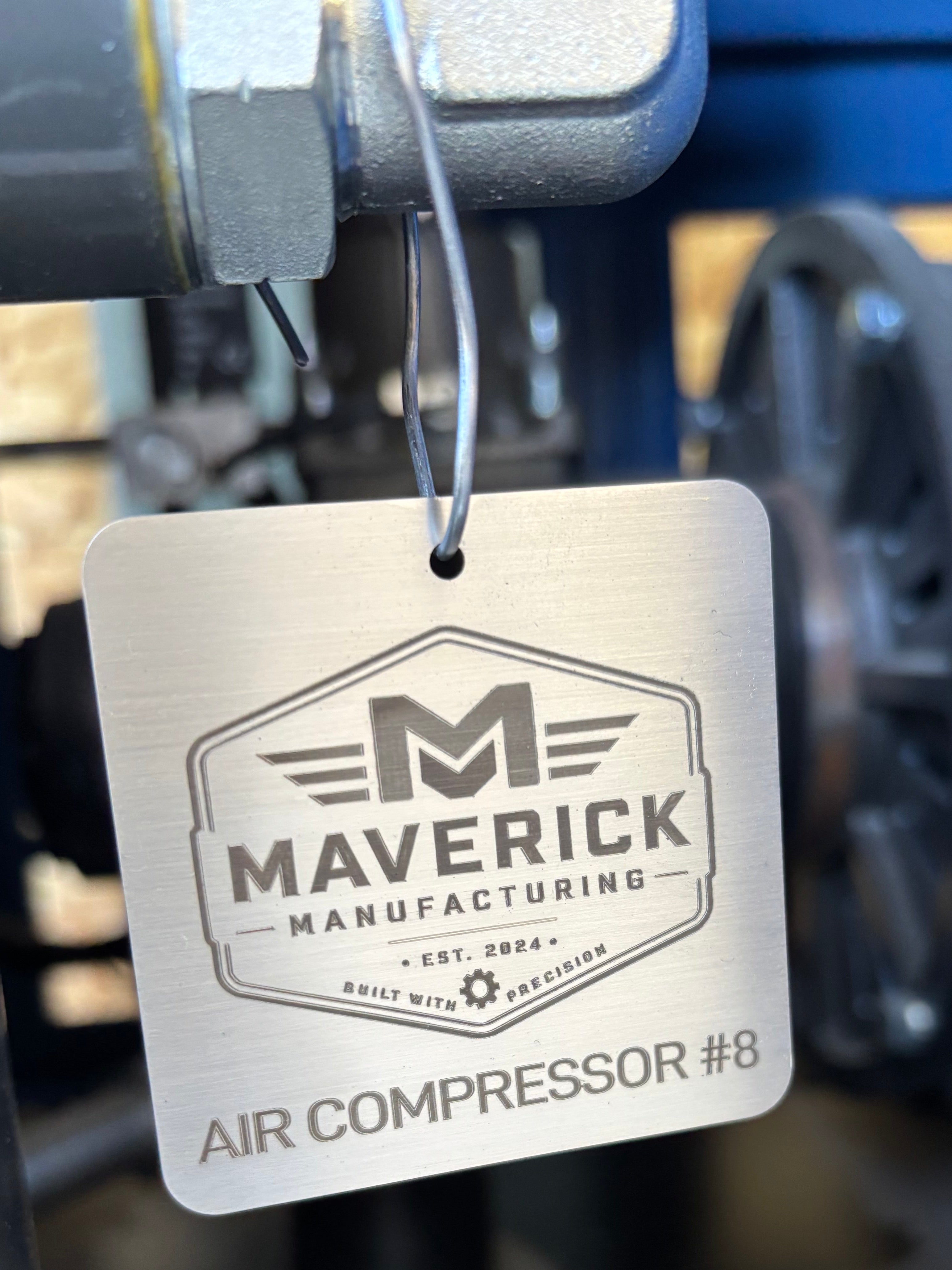 Custom stainless manufacturing tag with Maverick Manufacturing logo mounted on equipment