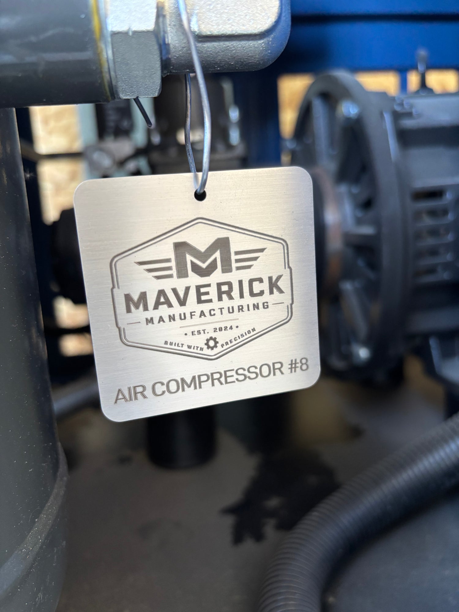 Maverick Manufacturing air compressor tag on a mechanical background