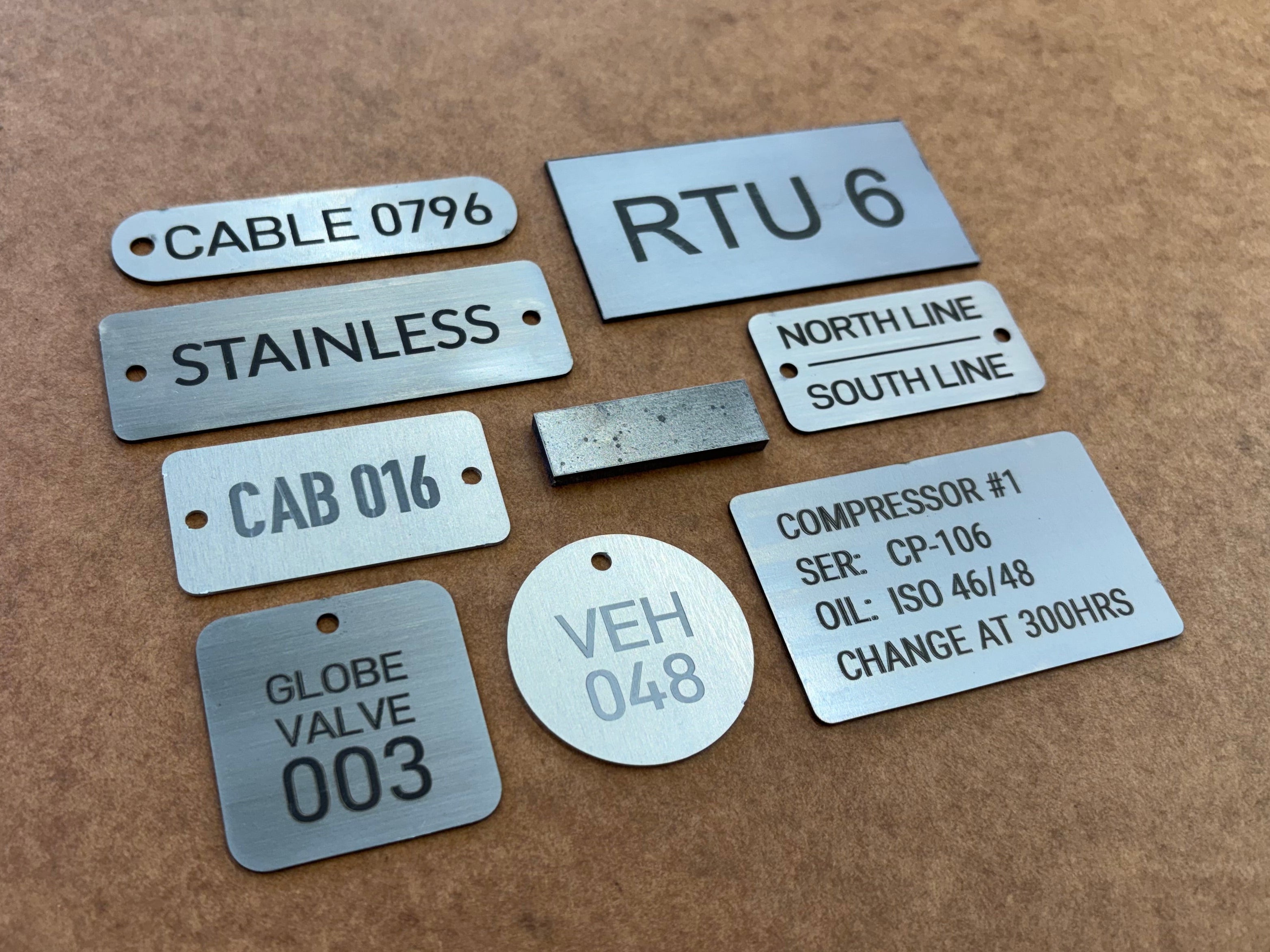 Set of metal tags with various inscriptions on a brown background