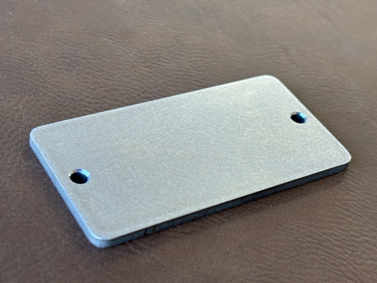 1.5" x 3" premium stainless nameplate – angled blank showing thickness and chamfered holes