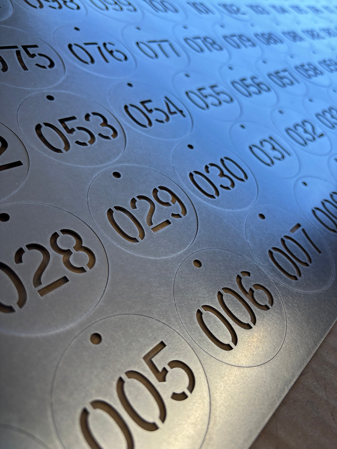 Two-inch round 20-gauge stainless cut-through tags with 0.75-inch sequential numbers